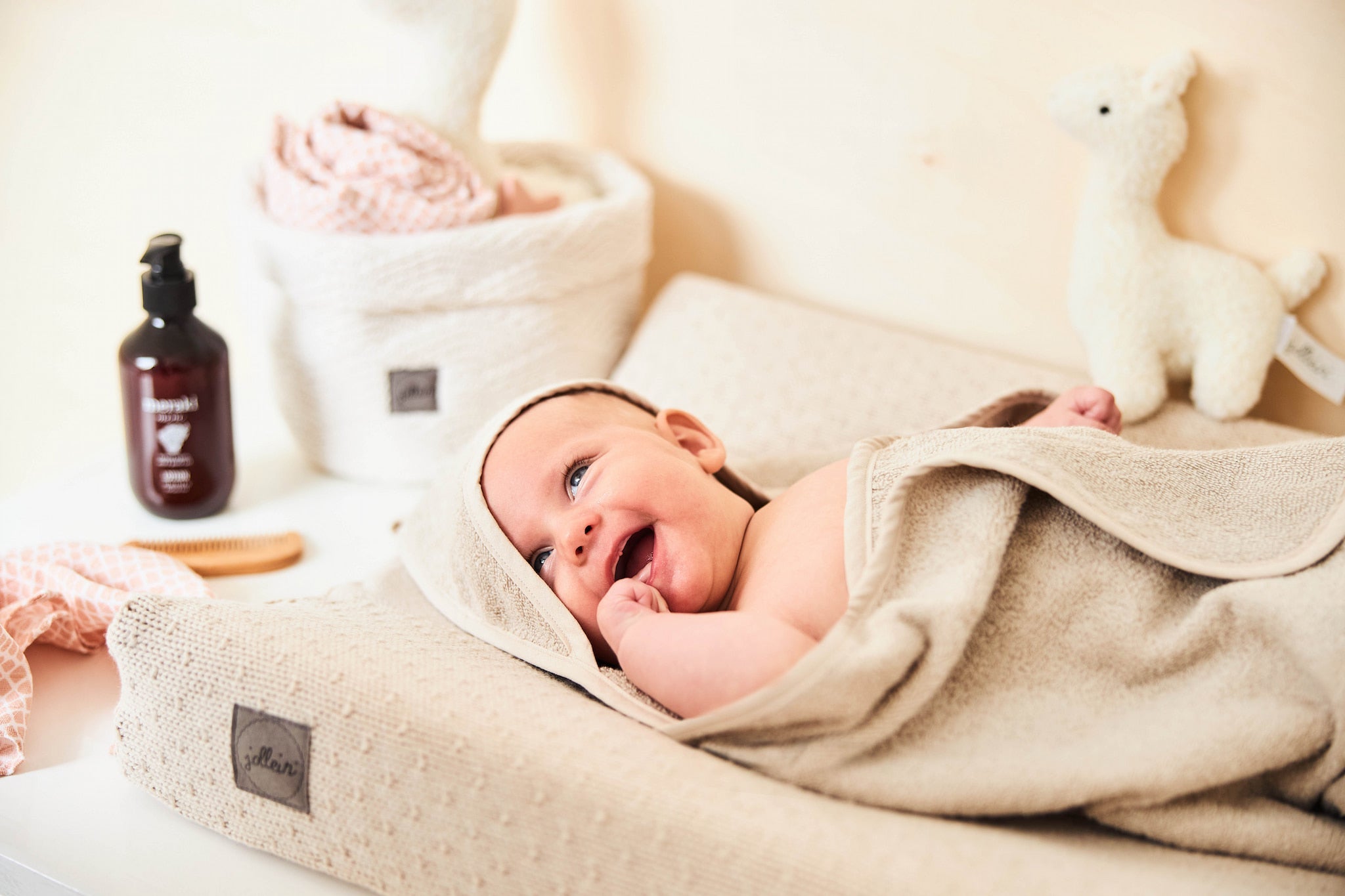 baby in een badcape op een verschoningskussen