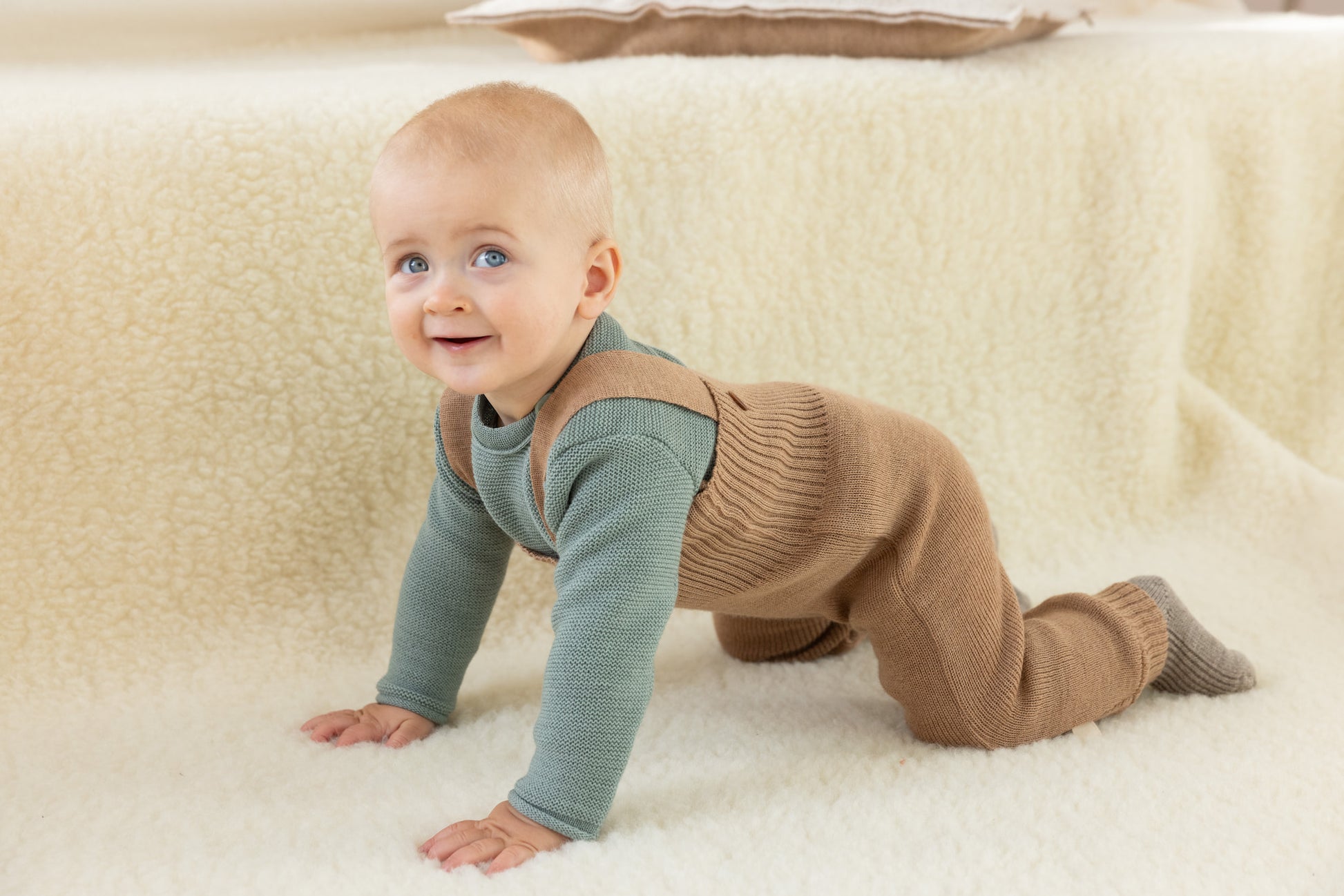 Wollen tuinbroek van Disana gedragen door kruipende baby