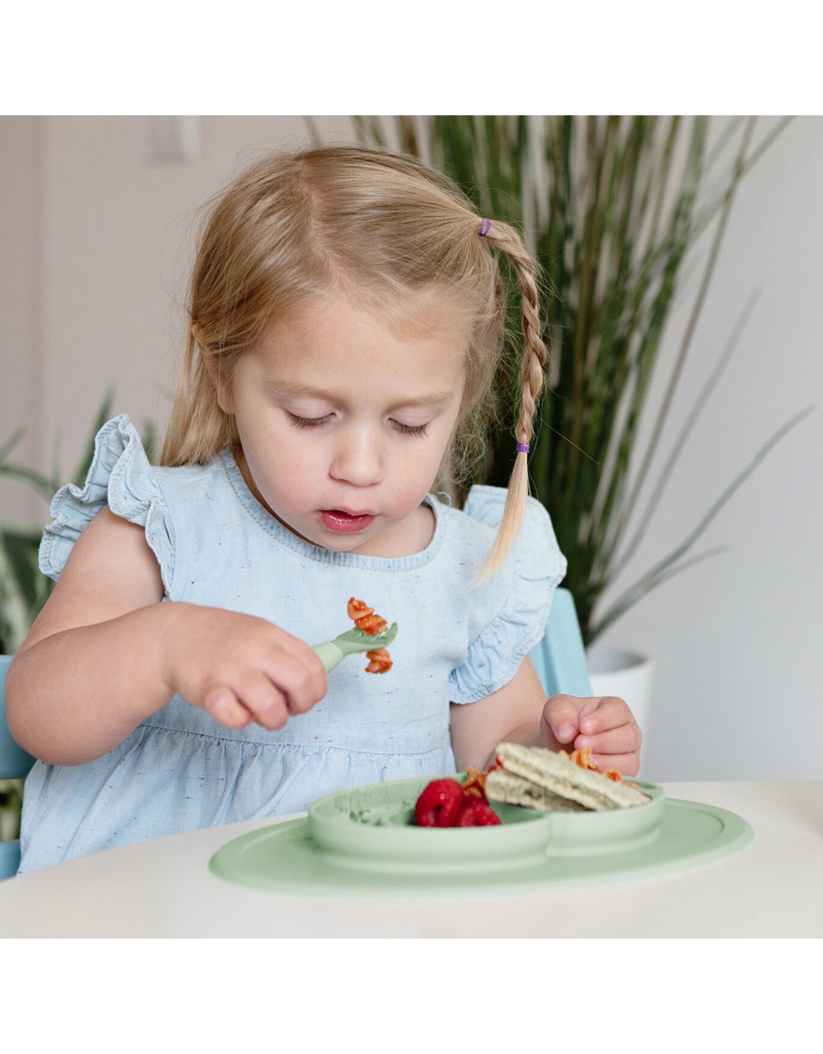 meisje eet met kindvriendelijke eetset met zuignap tegen knoeien