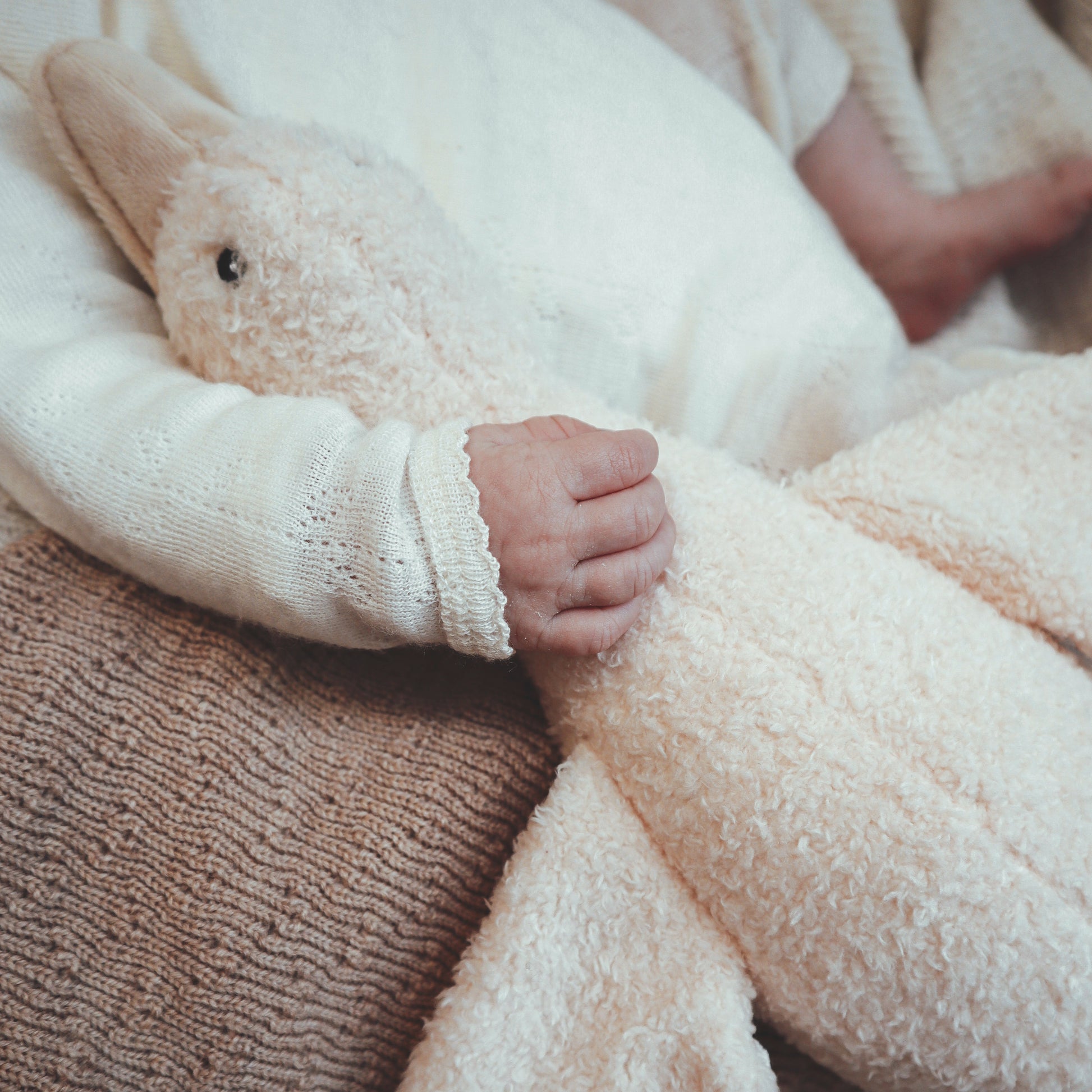 Detail van baby die knuffelt met Liva hartslagknuffel – zachte, geborgen rustgever met 5 geluiden