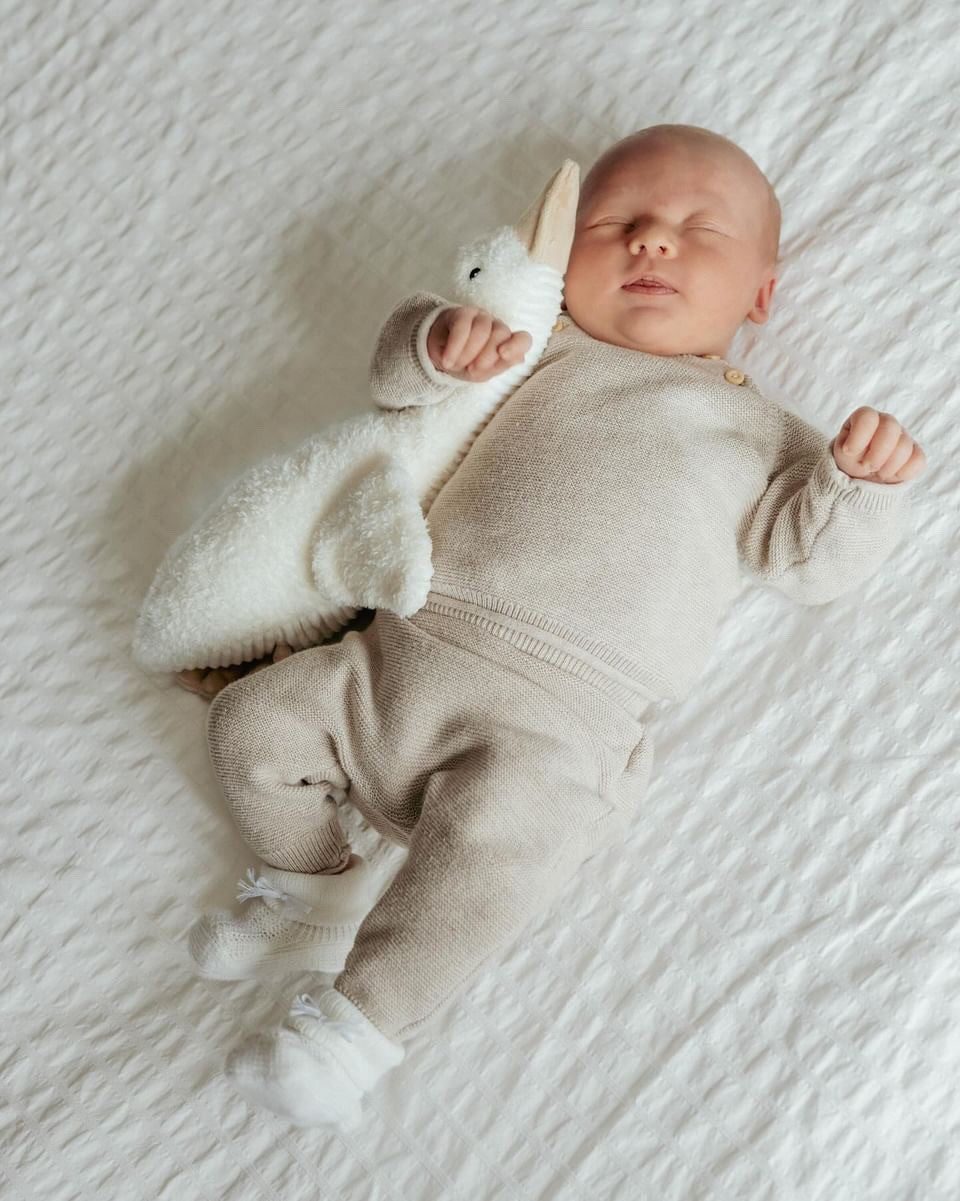 Baby slaapt ontspannen met de beige Liva hartslagknuffel van Flow – ideaal slaaphulpje met huilsensor