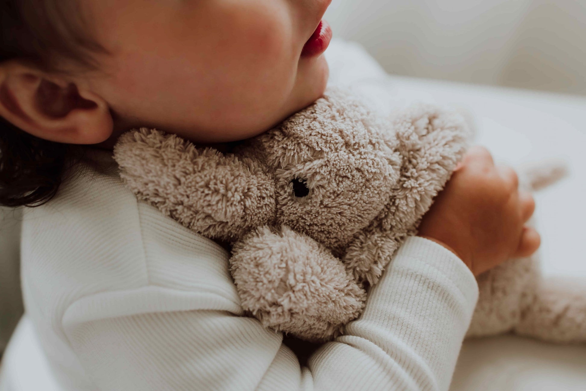 Kind knuffelt zachte witteruis knuffel van Flow Amsterdam