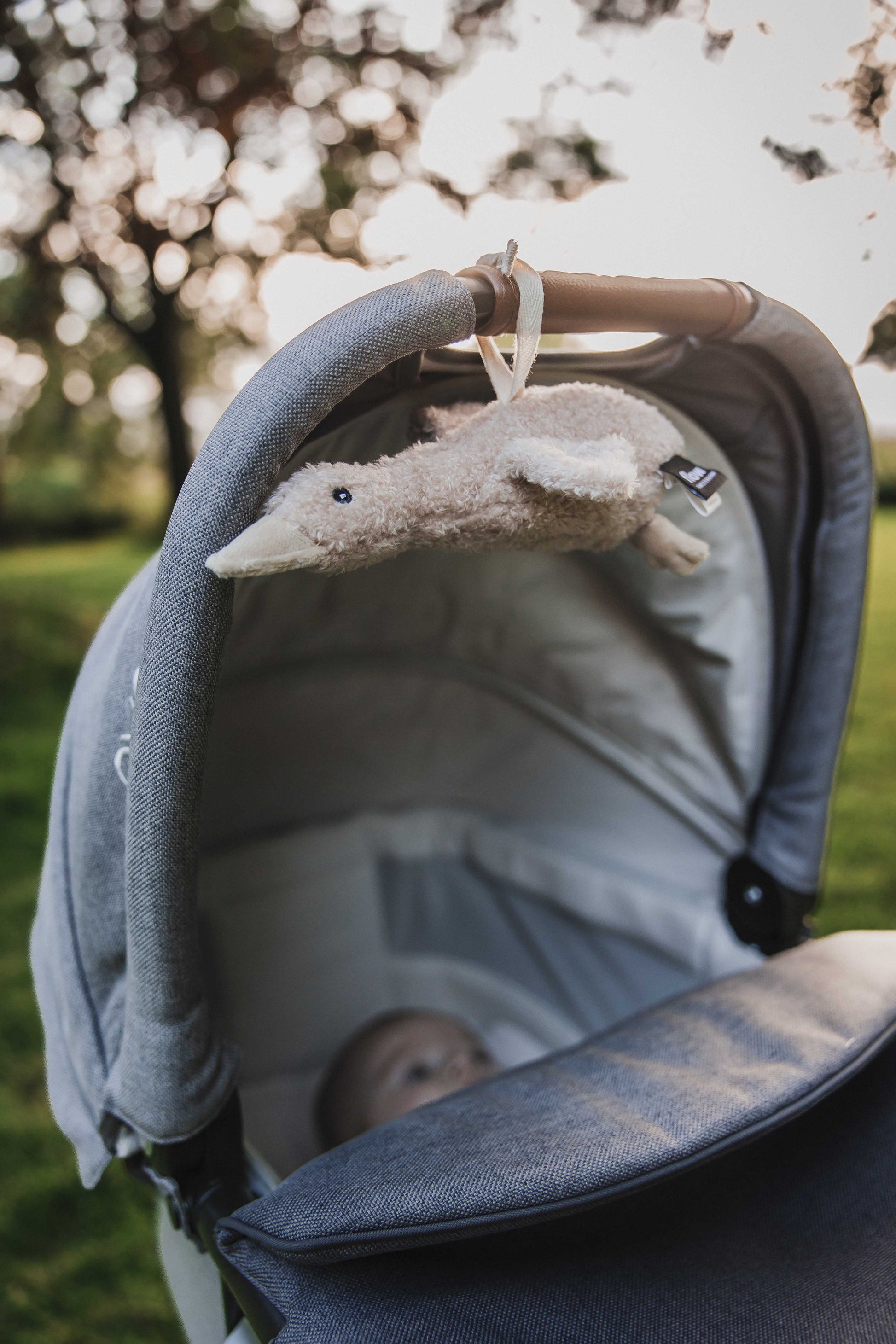 Flow Liva Oat hartslagknuffel hangend aan kinderwagen – rustgevende ruisknuffel voor onderweg