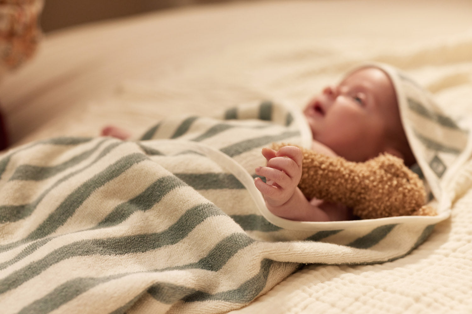 Sfeerbeeld van baby in badcape met capuchon, organisch katoen