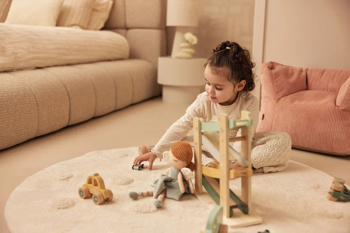 Meisje speelt met houten autobaan van jollein