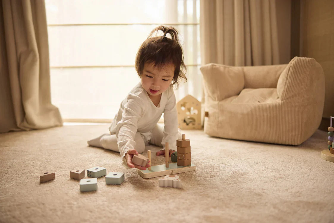 Kindje stapelt houten jungle dieren op elkaar