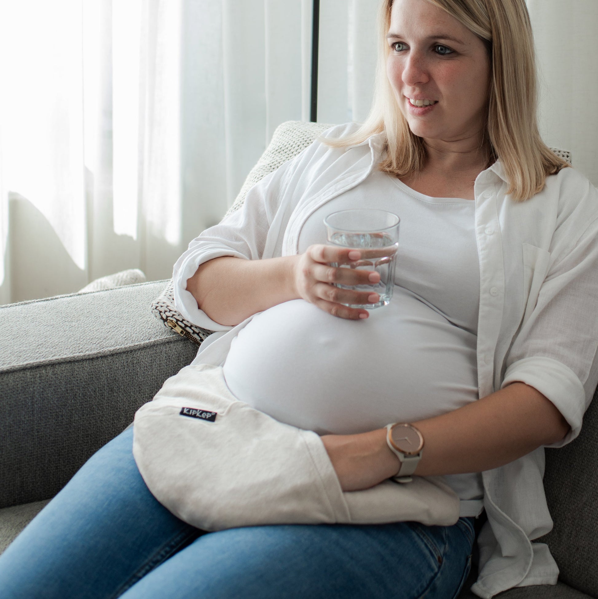 Gebruiker plaatst het warmtekussen op onderbuik voor ontspanning en comfort