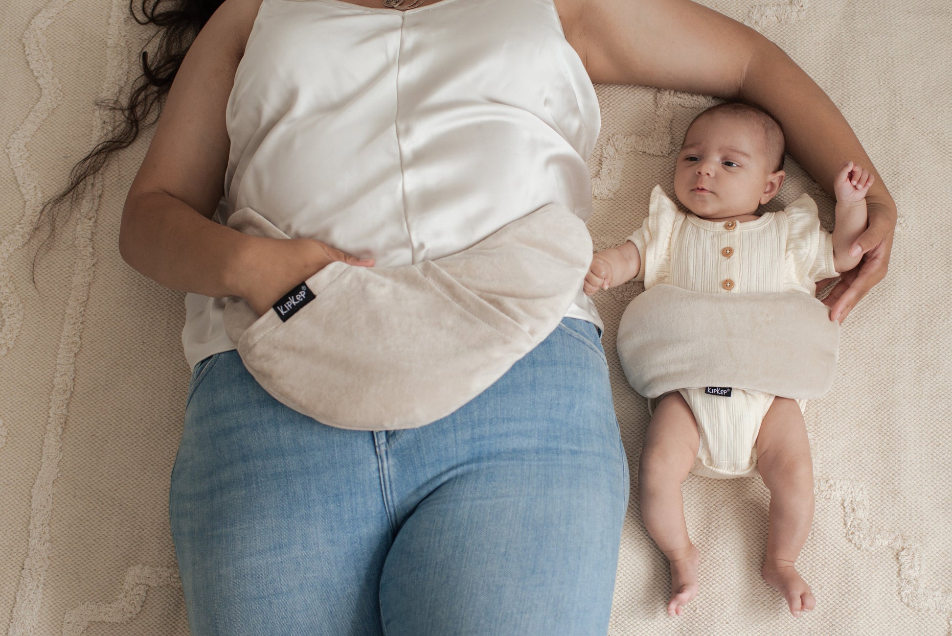 Vrouw met pasgeboren baby, Lexie Heating Pillow ondersteunend op buik voor herstel na bevalling