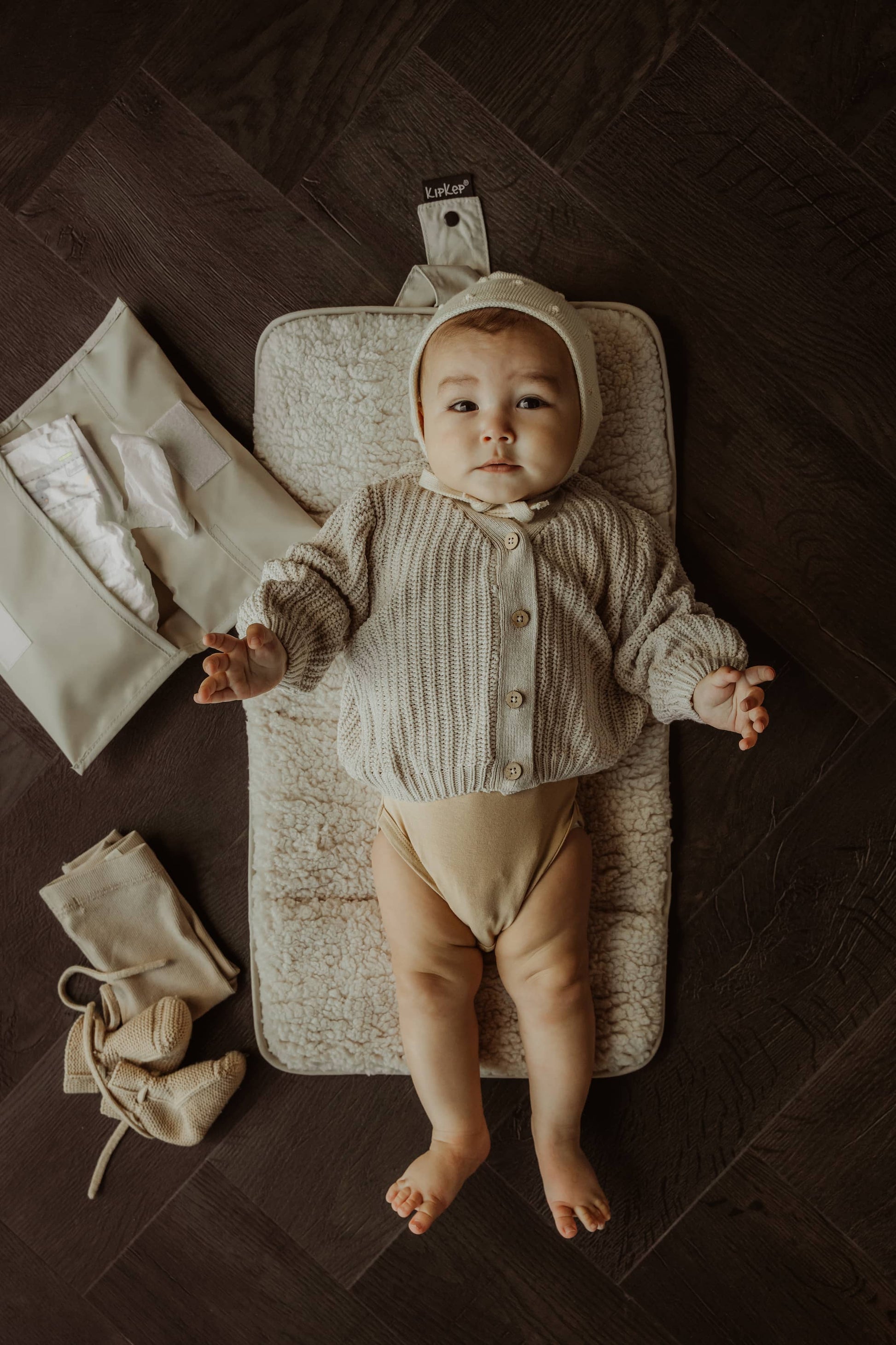 Baby liggend op verschoonmatje en handige luieretui van KipKep