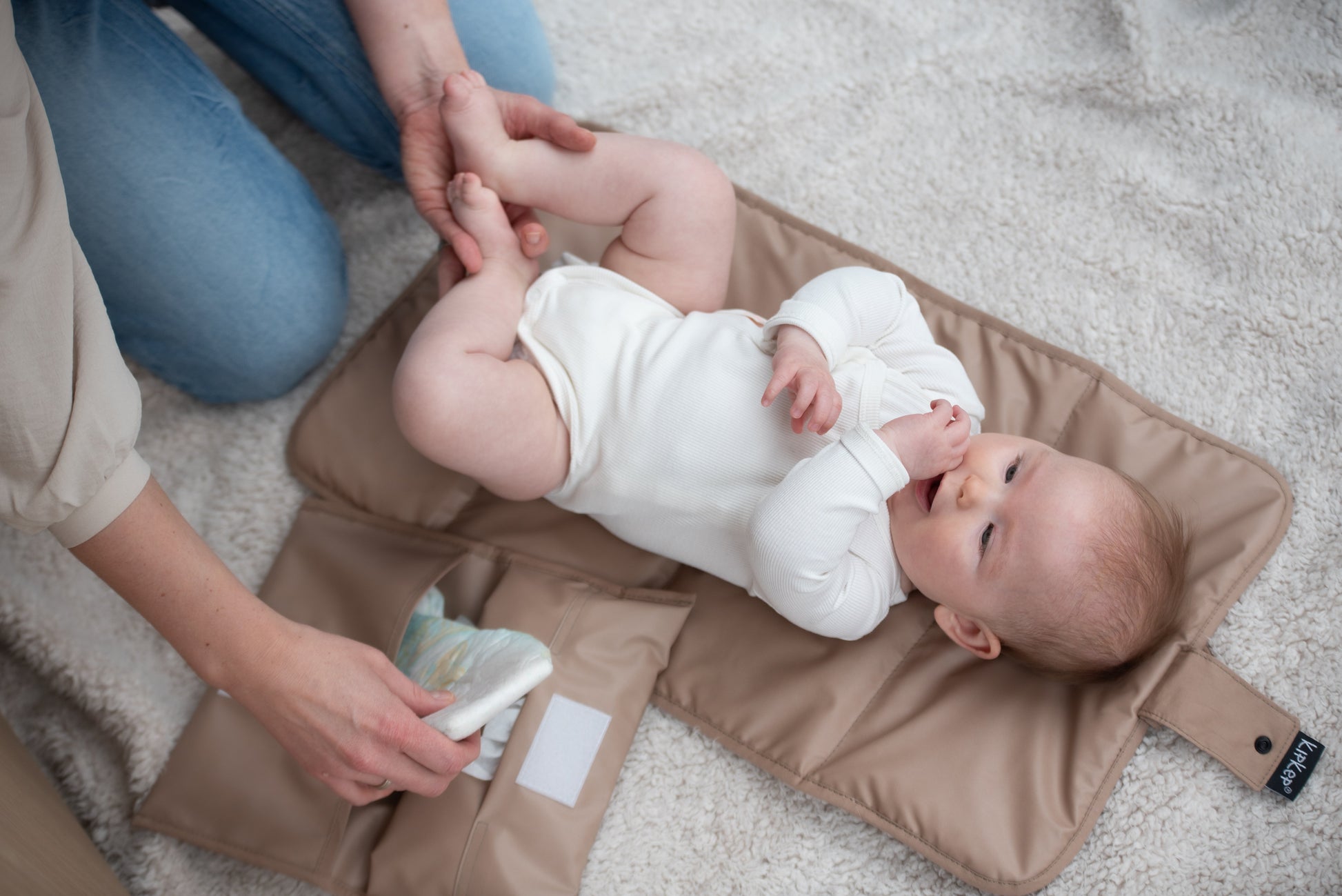 Baby liggend op het KipKep Napper Combi verschoonmatje – Coffee, comfortabel en hygiënisch