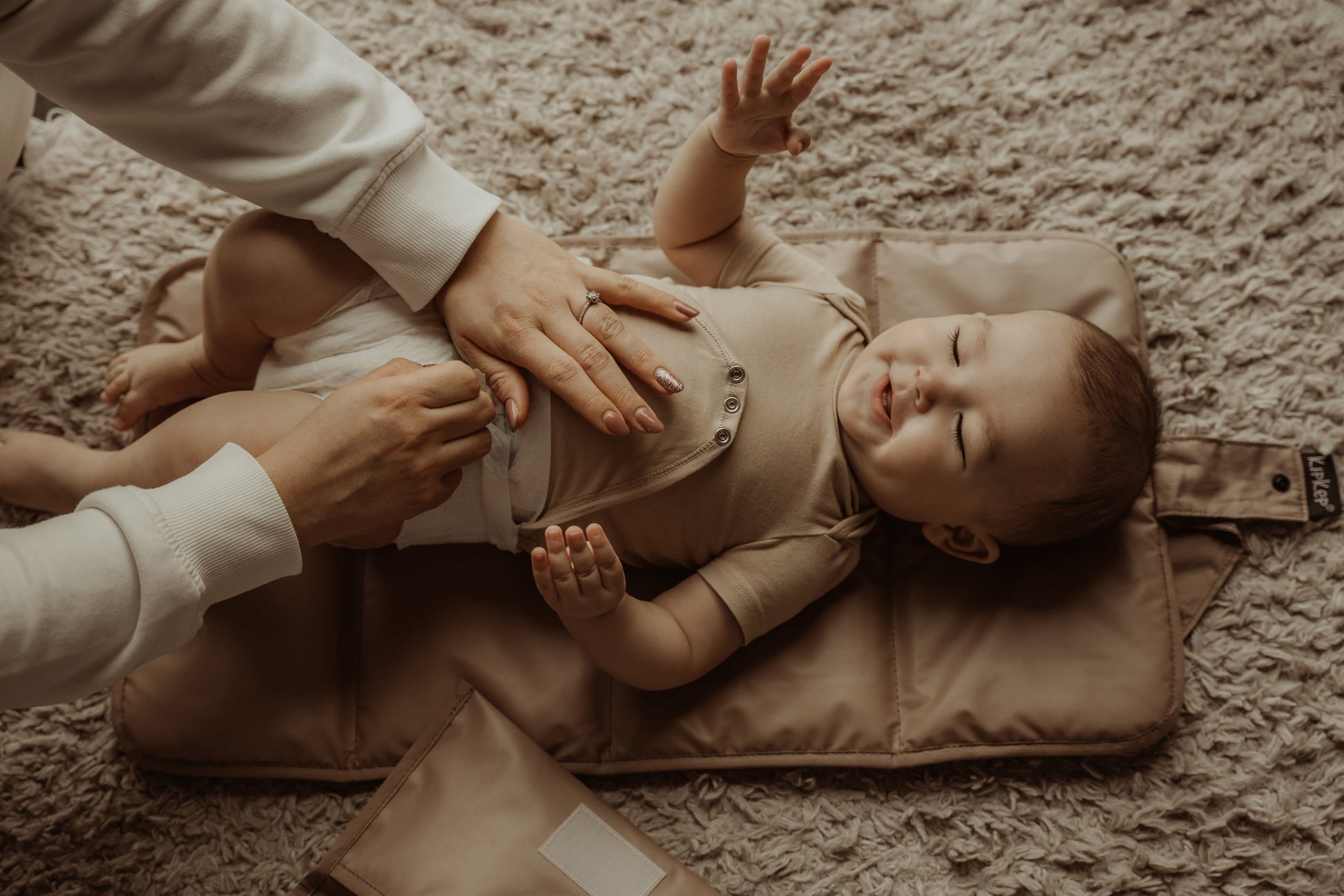 Sfeervol beeld van baby tijdens verschoning op het duurzame en waterafstotende KipKep matje
