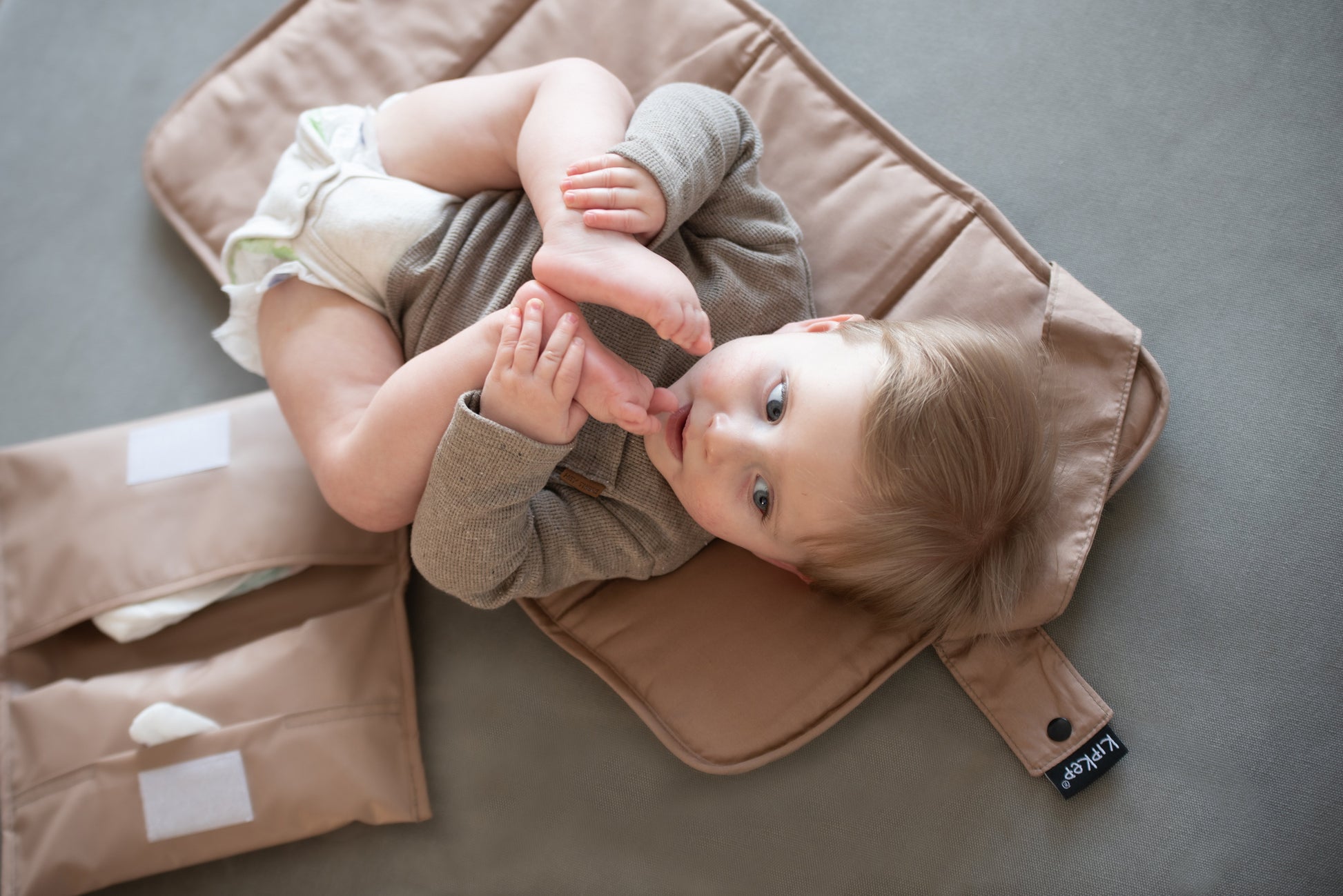 Kleintje op het opvouwbare KipKep verschoonmatje, compleet met bijbehorend etuitje voor luiers