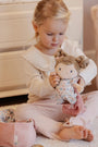 Kind verzorgt babypop Rosa en speelt met aankleden, knuffelen en verzorgen