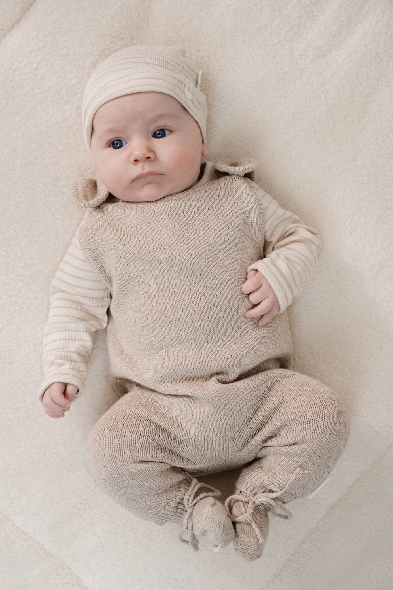 Baby draagt de zachte gebreide slofjes van Little Dutch