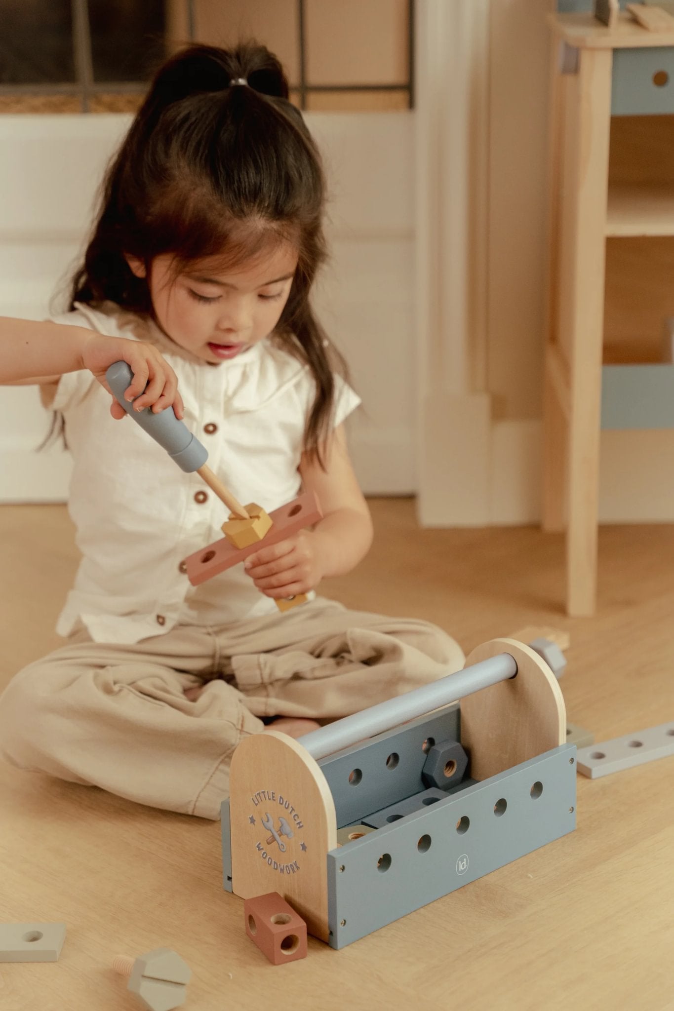 Meisje speelt met Little Dutch houten gereedschap tijdens fantasierijk rollenspel en zelfstandig ontdekken