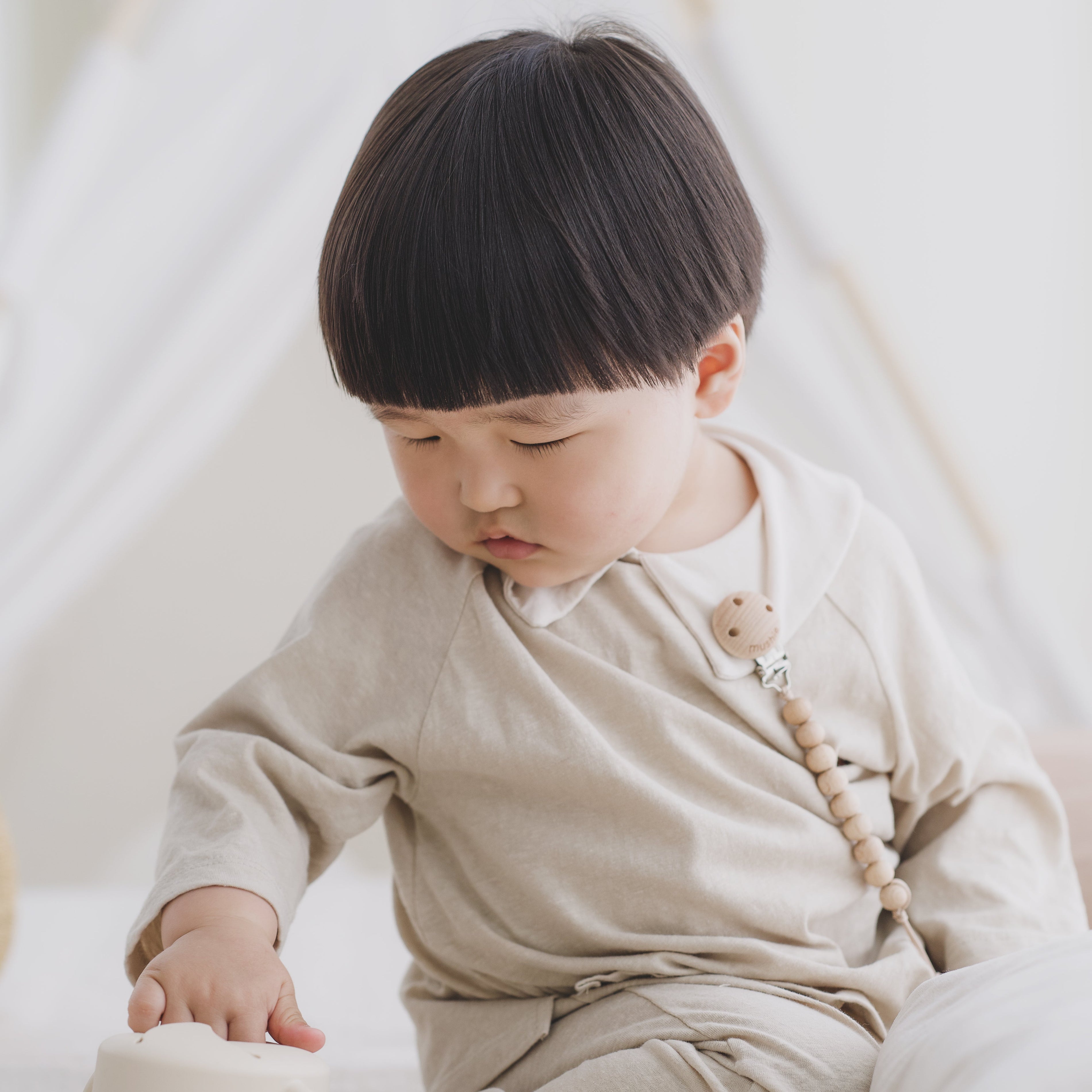 kindje pakt snack uit siliconen snackcup van mushie