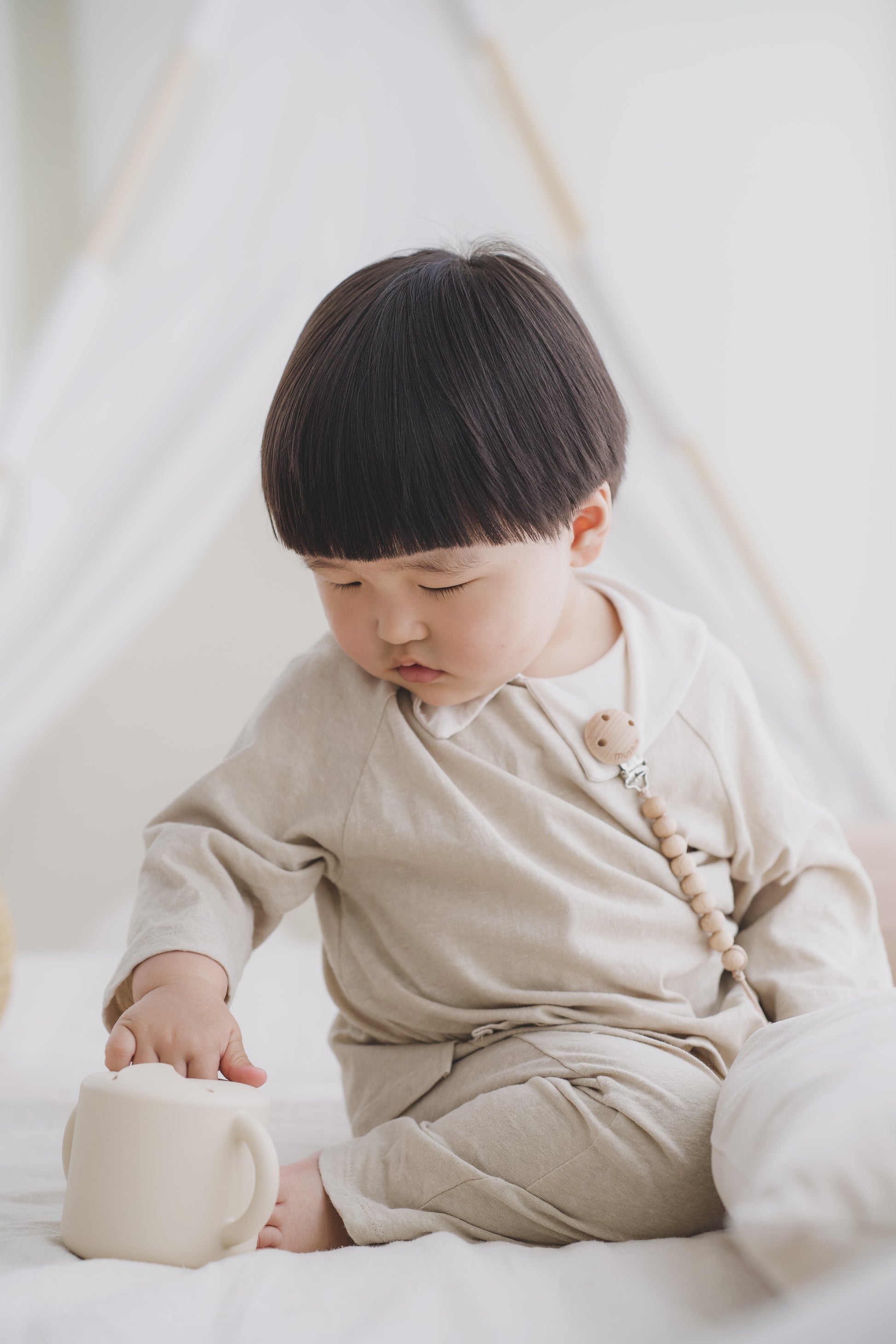 kindje pakt snack uit siliconen snackcup van mushie