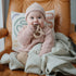Sfeerfoto van baby die op pretzel bijtring bijt van mushie