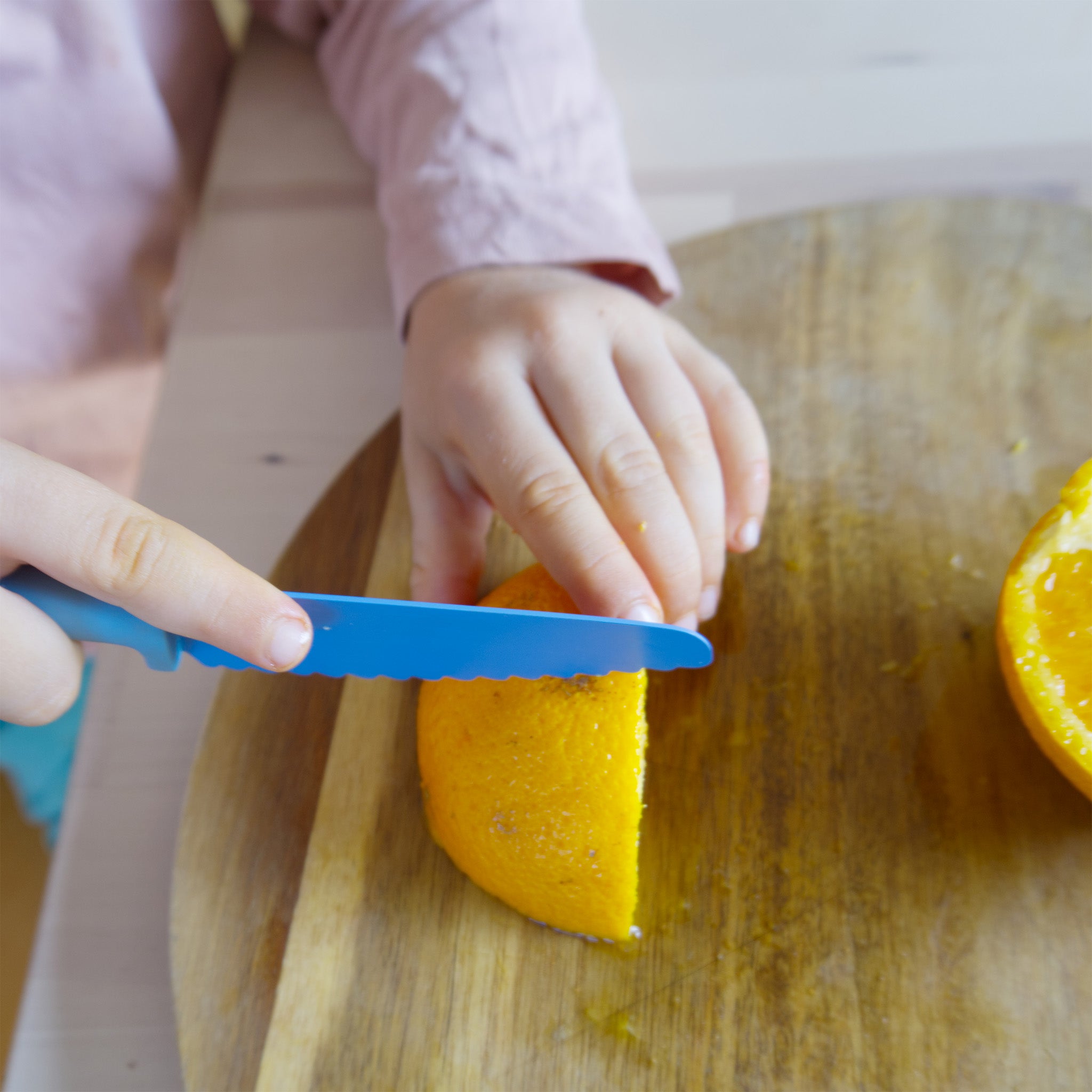 kind gebruikt SKÅGFÄ kindersnijmes in de keuken