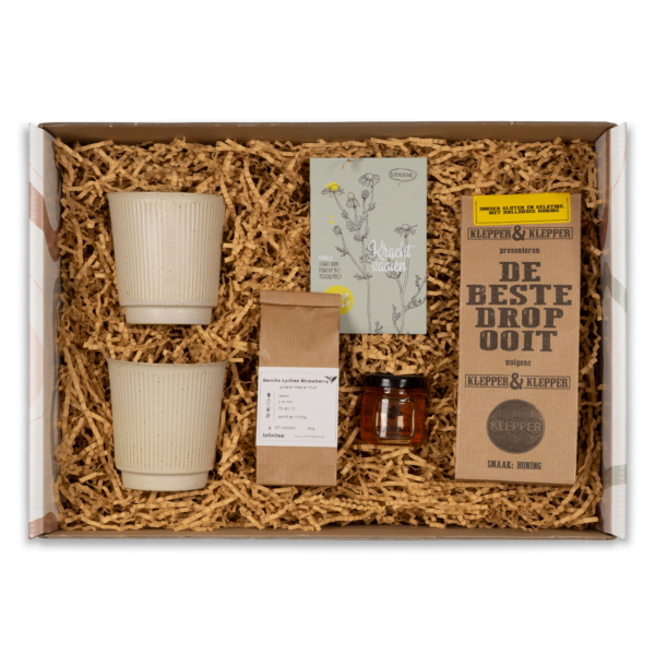 Laat iemand zich gesteund en gesterkt voelen met ons bijzondere 'Get well' cadeaupakket. Of het nu gaat om een beterschapswens, een steuntje in de rug bij een burn-out, dit pakket is de perfecte keuze. Het bevat twee prachtige mokken van House Doctor, waarmee de ontvanger kan genieten van hun favoriete thee of koffie. Verder vind je er lokale honing van Bijenbaas, natuurlijk heerlijk zacht en je draagt bij aan het ondersteunen van lokale bijenpopulaties. De losse thee van Infinitea is zorgvuldig geselecteerd om rust en ontspanning te bieden, terwijl de kamille bloemzaadjes van Veer&Moon symbool staan voor groei en veerkracht. Last but not least, hebben we de allerbeste honingdrop van Klepper & Klepper toegevoegd, een zoete traktatie om van te genieten en even te ontspannen. Of je nu een consument bent die iemand wil verwennen of een zakelijke klant die waardering wil tonen aan werknemers, ons 'Get well' cadeaupakket is een betekenisvol geschenk dat iemand eraan herinnert dat je er altijd voor hen bent. 